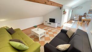 uma sala de estar com um sofá verde e uma mesa em Apartment More em Jadranovo