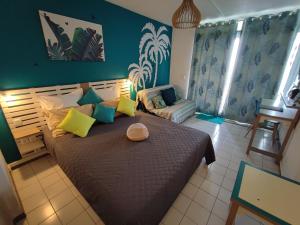 樂迪亞曼特的住宿－Un petit joyau，一间卧室配有一张大床,提供黄色和蓝色的枕头
