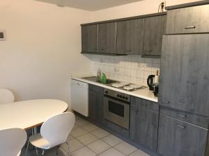 una cocina con armarios de madera, mesa y sillas en Apartment in handball city, Handewitt, en Handewitt