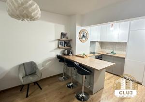 uma cozinha com um balcão, uma mesa e uma cadeira em Cluj Viva Aparthotel em Cluj-Napoca