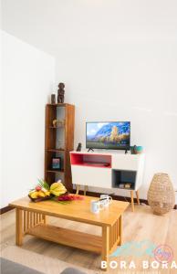 a living room with a tv and a coffee table at Black Pearl Lodge in Bora Bora