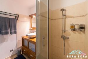 a bathroom with a shower stall and a sink at Black Pearl Lodge in Bora Bora