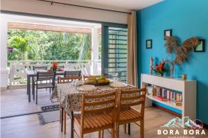 uma sala de jantar com paredes azuis e uma mesa e cadeiras em Black Pearl Lodge em Bora Bora