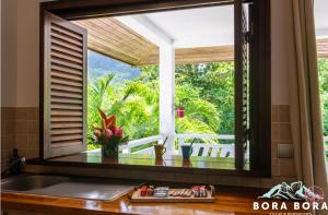 a kitchen window with a view of the garden at Black Pearl Lodge in Bora Bora
