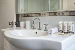 a white bathroom sink with towels and a mirror at BirdSong Yeronga - Inner City Village Sanctuary in Brisbane +17 photos