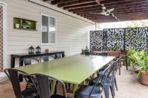 a green table and chairs on a patio at BirdSong Yeronga - Inner City Village Sanctuary in Brisbane