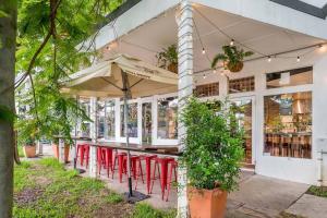 um restaurante com cadeiras vermelhas e um guarda-sol em BirdSong Yeronga - Inner City Village Sanctuary em Brisbane