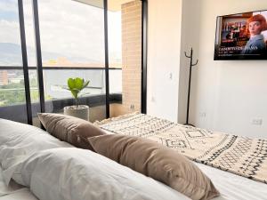 a bedroom with a bed with a tv on the wall at Class 48, Sabaneta in Sabaneta