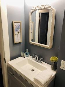 a bathroom with a sink and a mirror at Spacious Waterfront Cottage + 2.5 Acres on the Bay in Lafayette