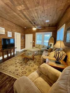 uma sala de estar com dois sofás e uma televisão em Spacious Waterfront Cottage + 2.5 Acres on the Bay em Lafayette