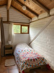 ein Schlafzimmer mit einem Bett in einem Zimmer in der Unterkunft Casa Semilla in Cotacachi
