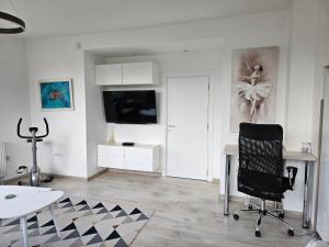 ein Wohnzimmer mit einem Schreibtisch und einem Stuhl in der Unterkunft Villa Hris I WiFi-Netflix in Skopje