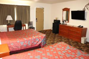 Una habitación de hotel con dos camas y un televisor de pantalla plana. en Best Nights Inn - Sparta, en Sparta