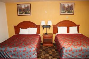Una habitación de hotel con dos camas y dos lámparas. en Best Nights Inn - Sparta, en Sparta
