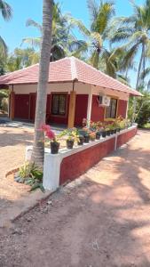 a house with potted plants in front of it at Bekal Village Homestay in Kāsaragod