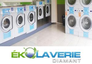 a laundry room with three washing machines in a store at Un petit joyau in Le Diamant