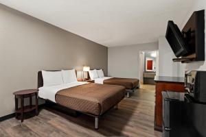 a hotel room with two beds and a flat screen tv at Rodeway Inn in Brooklawn