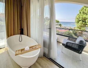 a bathroom with a tub and a large window at Botanica Boutique Hotel in Ulcinj