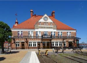 a large brick building with a clock on it at Grand Station - Restaurang & Rooms in Oskarshamn
