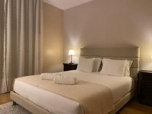 a bedroom with a large white bed with two lamps at S. Mamede House - Penafiel in Recezinhos