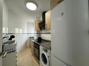 a kitchen with a washer and dryer in it at Experience Valencia Bnb - Mare Nostrum Apartment Beach Puerto Sagunto in Puerto de Sagunto