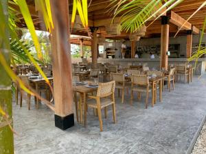 een restaurant met houten tafels en stoelen en een bar bij Casa Serena + The Pool Club @ Mahogany Bay in San Pedro