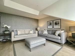 a living room with two couches and a table at Mere View Loft, Bowness-on-Windermere in Bowness-on-Windermere