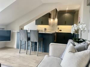 a living room with a couch and a kitchen at Mere View Loft, Bowness-on-Windermere in Bowness-on-Windermere