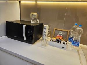 a counter with a microwave and bottles of water at Villa Hris I WiFi-Netflix in Skopje