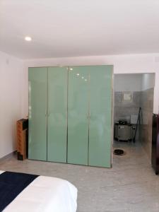 a large glass cabinet in a bedroom with a bed at Bekal Village Homestay in Kāsaragod