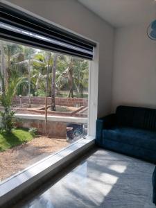 a living room with a couch and a large window at Bekal Village Homestay in Kāsaragod