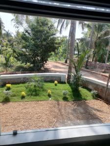 a view of a garden from a window at Bekal Village Homestay in Kāsaragod