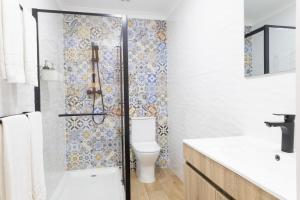 a bathroom with a toilet and a glass shower at Vinyl Flat Bed & Breakfast - Rooms in Lagos