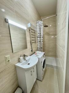 La salle de bains est pourvue d'un lavabo et d'un lave-linge. dans l'établissement M25 Aparts, à Lviv