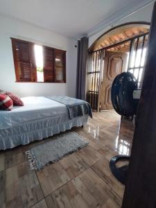 1 dormitorio con 1 cama y suelo de madera en Refúgio na Praia en Ilhabela