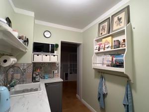 a kitchen with white shelves and a sink at Casa Dísa - Dreams, A Boutique Guesthouse in Reykjavik City`s Central Park and Botanical Garden in Laugardalur, Hot-Spring-Valley in Reykjavík