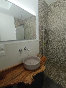 a bathroom with a sink on a wooden counter with a mirror at RESIDENCE TERRAE Intero appartamento 2 CAMERE MATRIMONIALI in San Ligorio +46 photos