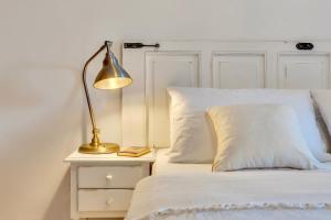 a white bed with a lamp on a night stand at Casita Bonita - with private garden near beach in Jávea in Jávea