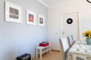 una sala da pranzo bianca con tavolo e sedie di Vinyl Flat Bed & Breakfast - Rooms a Lagos