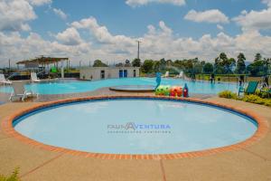 蒙特内哥罗Apartamento Faunaventura cerca Parque del Café con piscina的一座带雕像的度假村的大型游泳池