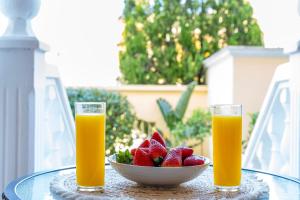 two glasses of orange juice and a bowl of strawberries at Casita Bonita - with private garden near beach in Jávea in Jávea