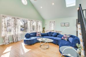 a living room with a blue couch and a table at Cozy Rhode Island Retreat with Yard, Near Beaches! in North Kingstown