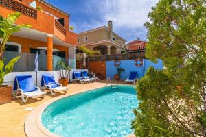 una piscina con sillas azules y una casa en Casas Novas Guesthouse - Adults Only en Lagos