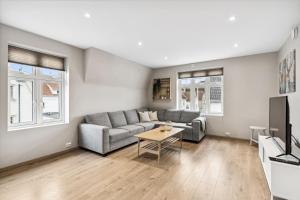 a living room with a couch and a table at Romslig 3-soveroms toppleilighet midt i sentrum in Egersund