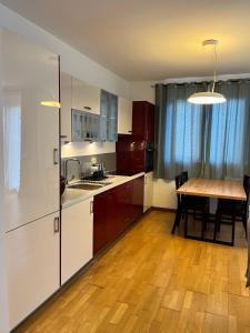 een keuken met een tafel en een houten vloer bij Blue lagoon apartment Przno in Budva