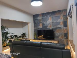 a living room with a black couch and a tv at SPA HOUSE 2 in Tías +22 photos