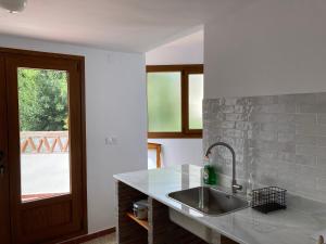 une cuisine avec un évier et une fenêtre dans l'établissement L57 - Habitaciones en Órgiva, à Órgiva