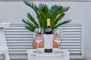 a bottle of wine and two wine glasses on a table at Casita Bonita - with private garden near beach in Jávea in Jávea