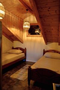 2 Betten in einem Zimmer mit Holzdecken in der Unterkunft Scodrinon Hostel in Shkodra