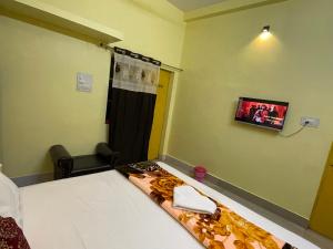 een slaapkamer met een bed en een tv aan de muur bij SHANKR VILAAS benaras Luxury stay in Varanasi